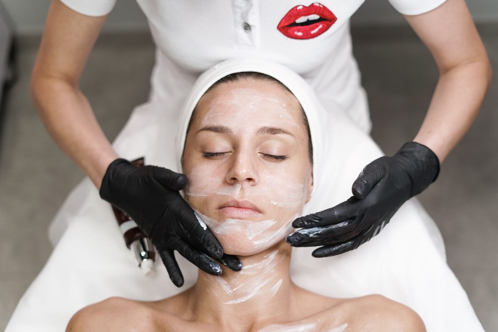 A therapist finishing a facial treatment at CHAIR